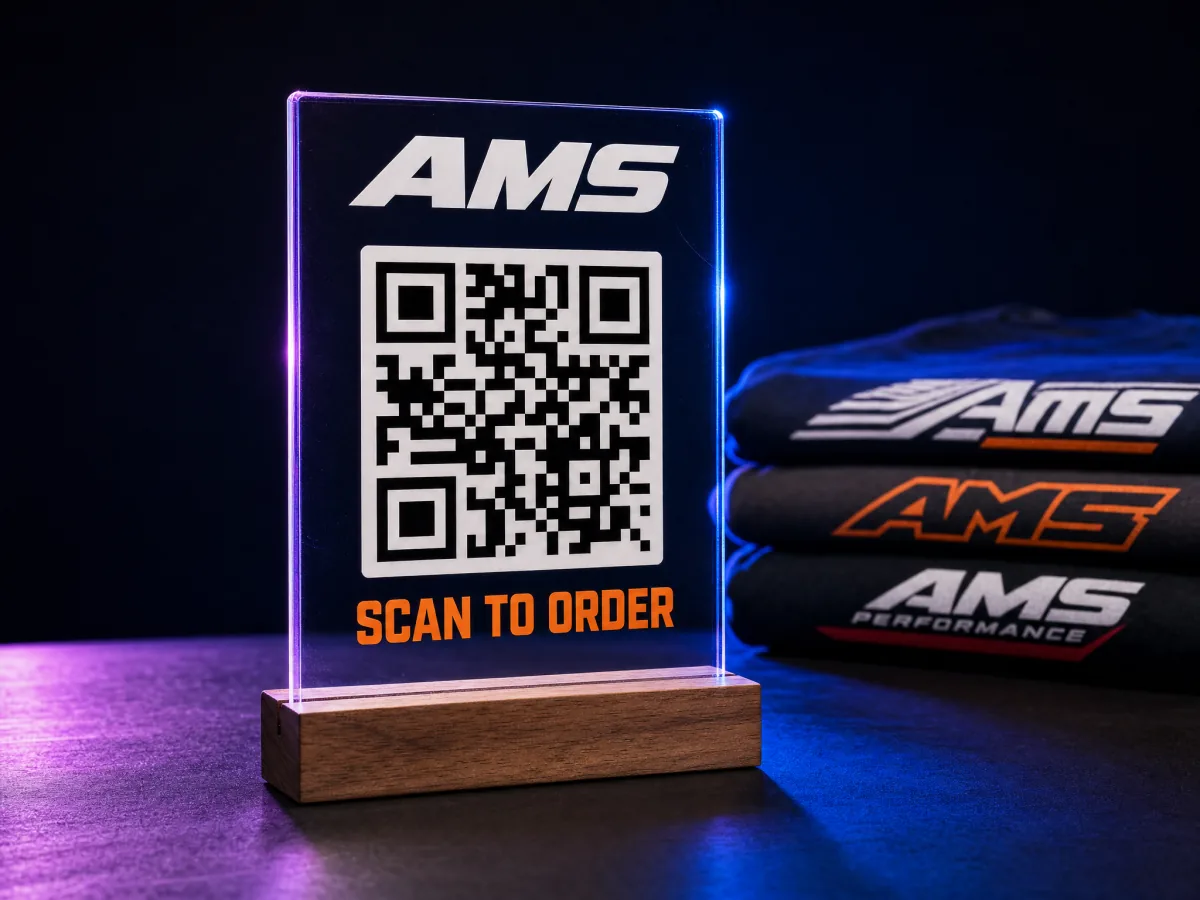 A clear acrylic tabletop sign with a logo, a large QR code, and the words scan to order