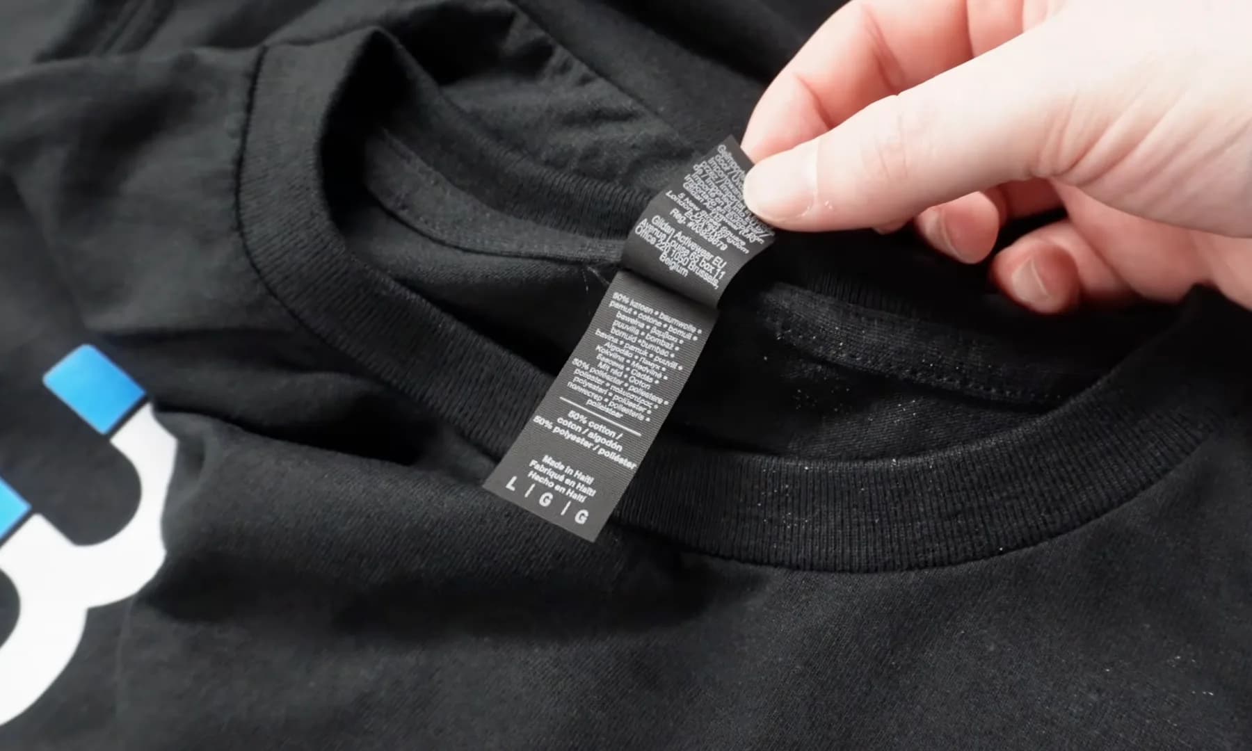 Inside care label on a black Gildan DryBlend shirt showing the 50 percent cotton and 50 percent polyester fabric blend